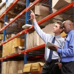 Two Businessmen With Digital Tablet In Warehouse